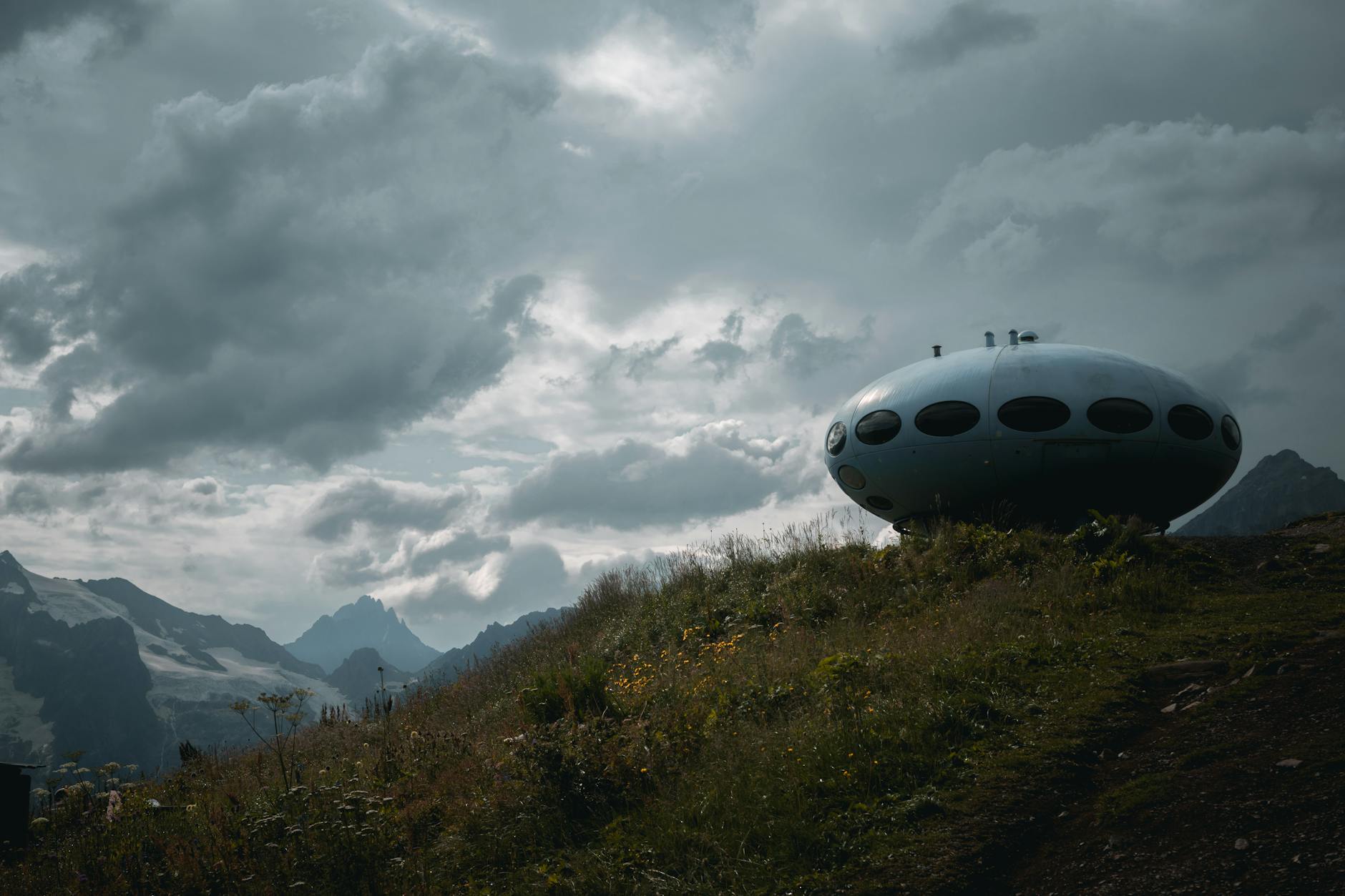 solarpunk hovel on grass field under gray clouds